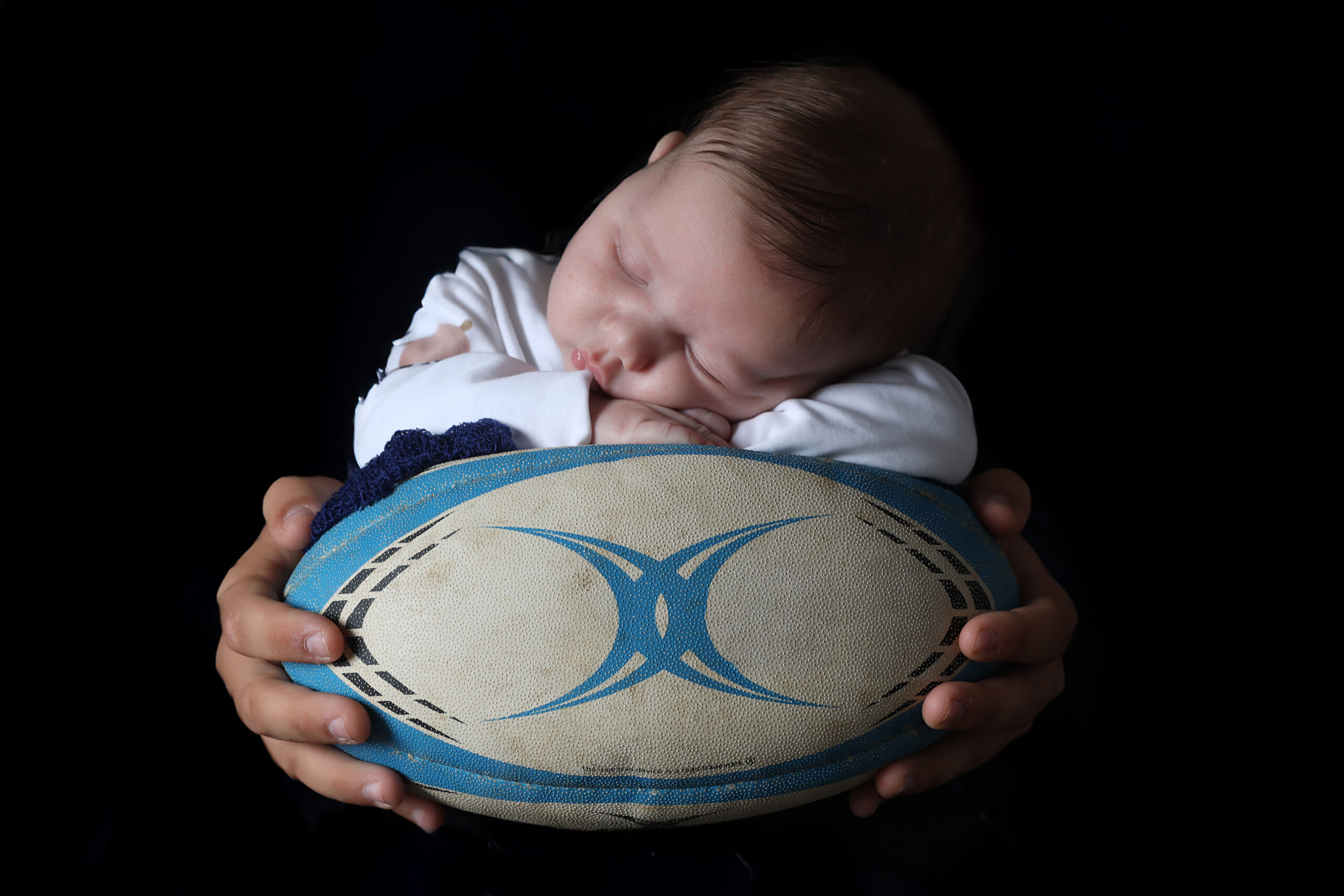Séance photo bébé avec ballon de rugby : une passion et l’être le plus cher réunis en images